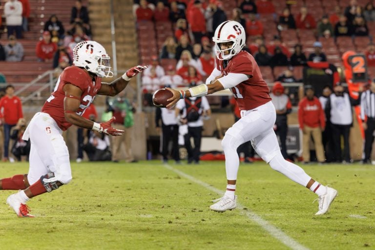 True freshman QB Ari Patu (11 right) hands off to junior RB EJ Smith (22 left) during a game against the University of Utah.