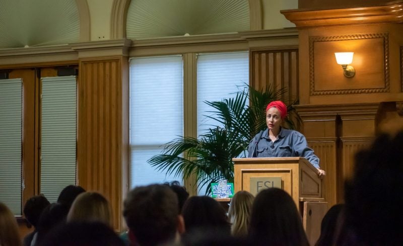 Zadie Smith, acclaimed author, stands at podium in front of rows of Stanford students and faculty.