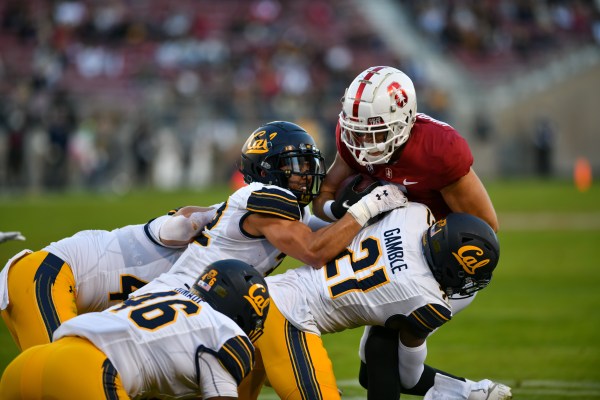 A photo of sophomore wide receiver John Humphreys being tackled by Cal defenders