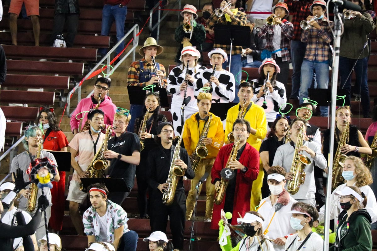 Stanford band members dressed in costume play their instruments form the bleachers.