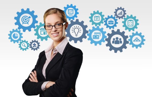 suited woman wearing glasses in front of clip art gears