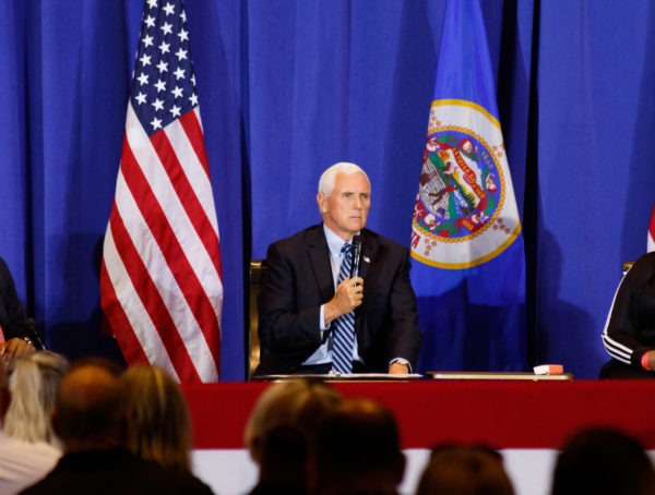Picture of Mike Pence in front of two flags at a conference