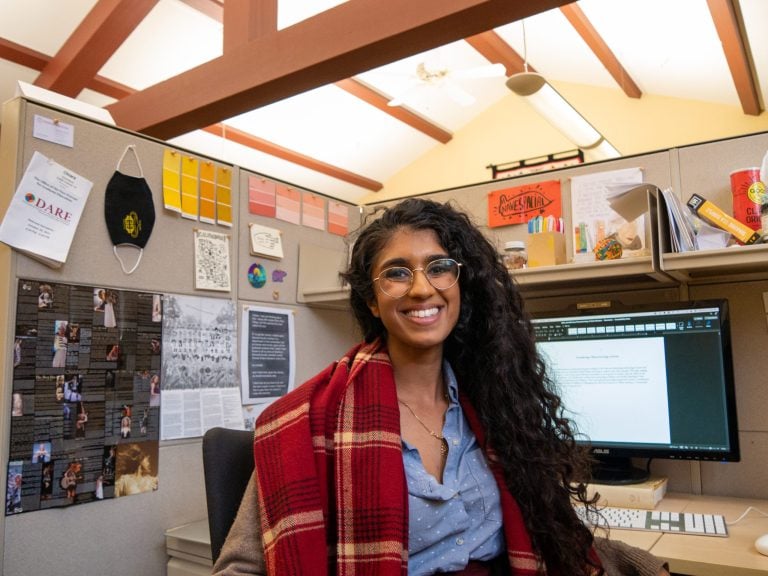 Chiara Giovanni smiling in a chair in her cubicle