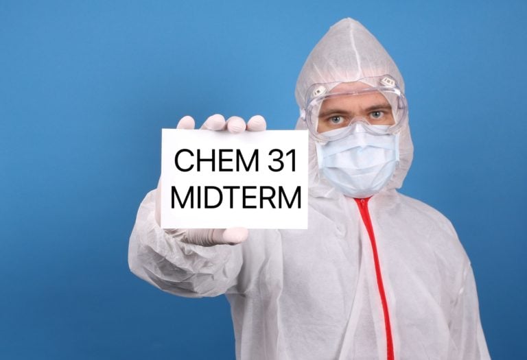 person in full PPE holding out a card reading 'CHEM 31 MIDTERM'
