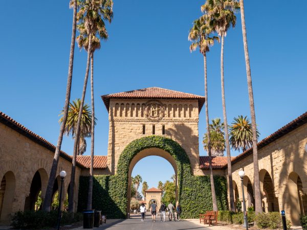An arch looking into Main Quad with palm trees lining the road