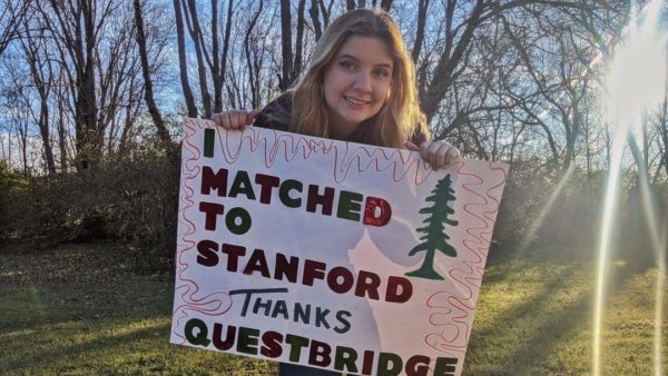 Isidora Davis holds sign that reads "I Matched To Stanford, Thanks QuestBridge"