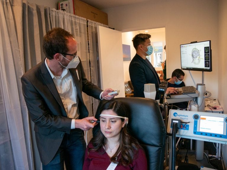 Doctor performs brain treatment on staff member in chair