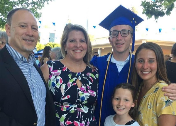 Eitan Weiner stands with his family in a cap and gown