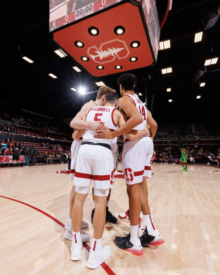 Stanford men's basketball huddles on the court in Maples Pavilion.