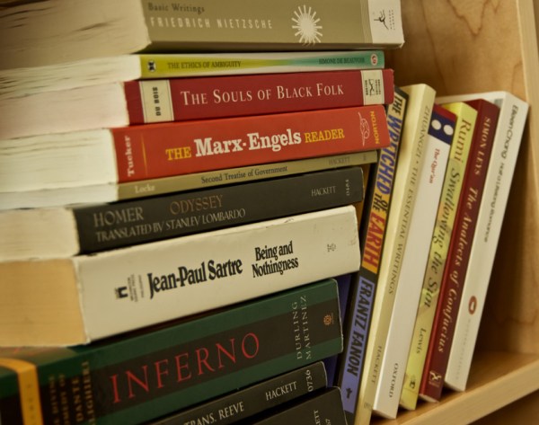 A stack of books on a shelf covering a variety of humanist topics.