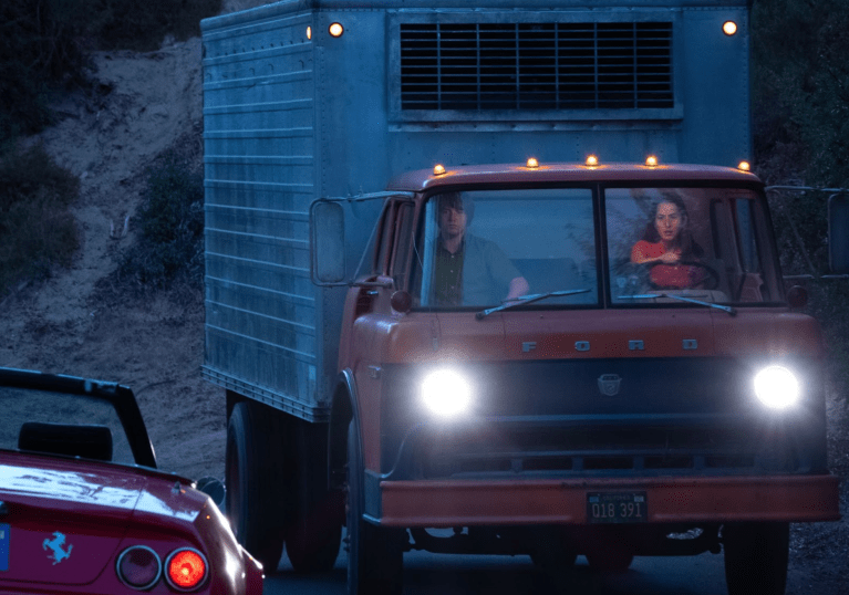 Stars Haim and Hoffman sit in a truck.