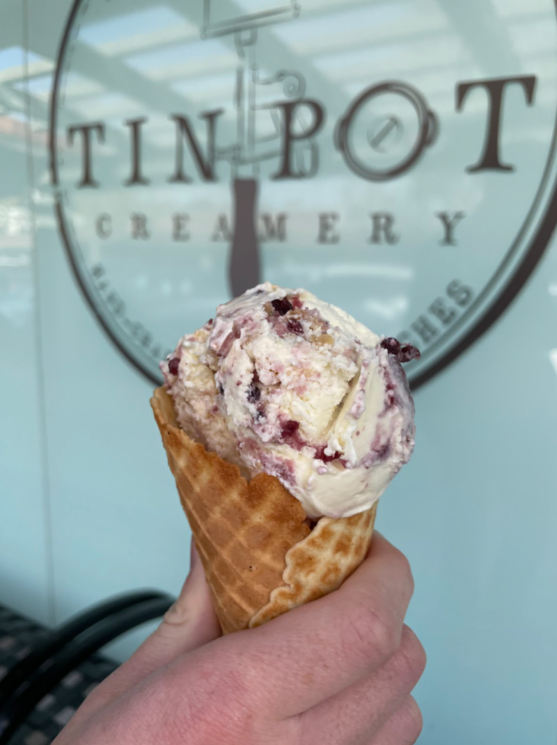 picture of hand holding ice cream in front of TinBot storefront