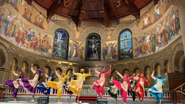 Dancers for Stanford Bhangra perform at Memorial Church in colorful traditional attire.