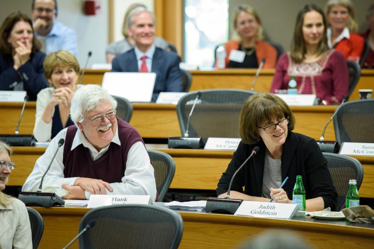 Faculty Senate members sitting at their desks smiling