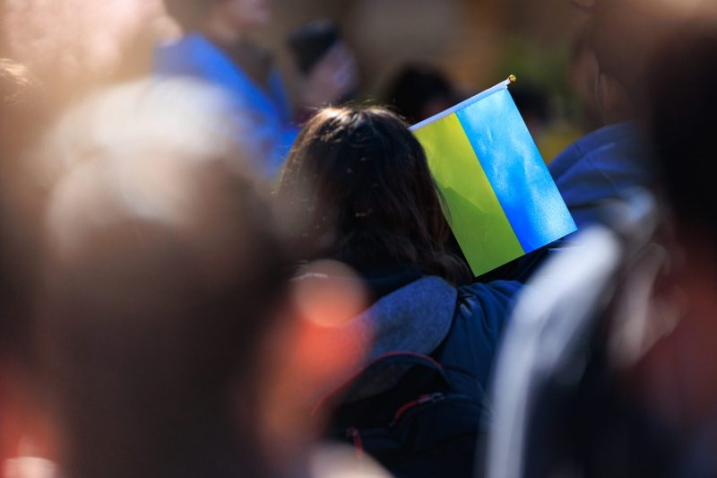A Stanford community member holds a Ukrainian flag while gathering in Main Quad to show support for Ukraine amid the ongoing Russian invasion of Ukraine.