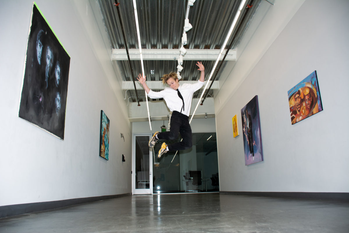 Gunner Dongieux jumps with his arms raised in the middle of his featured exhibition at Stanford's Mohr Gallery (Photo courtesy of Gunner Dongieux and Lucy Brewer)