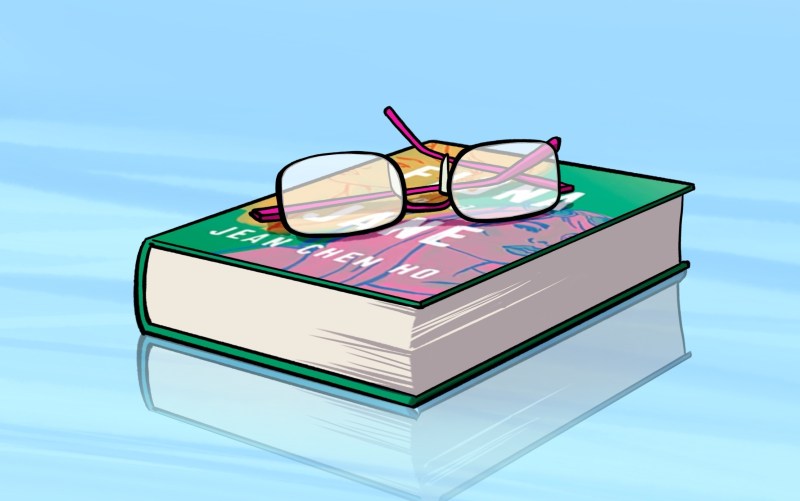 Green and pink book with glasses sitting on top; blue background