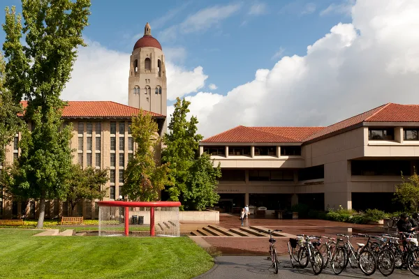 Green Library against a cloudy sky with Shumway Fountain in the foreground and Hoover Tower in the background.
(Photo: LINDA A. CICERO/Stanford News Service)