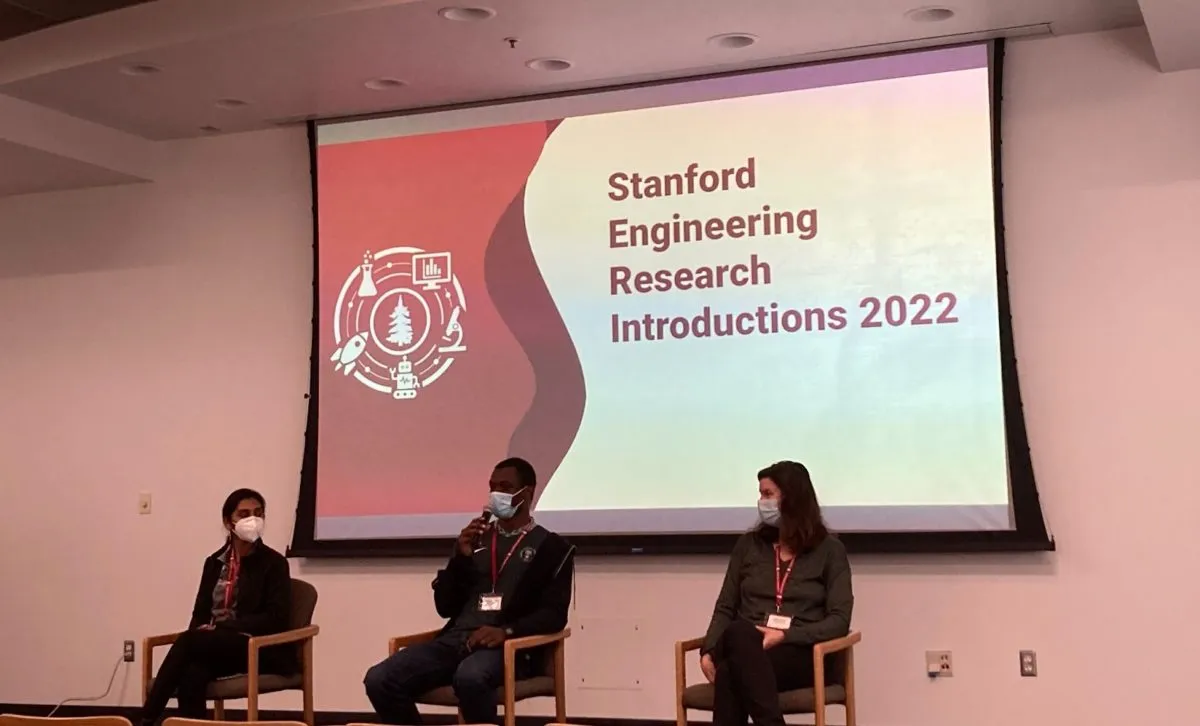 Three graduate student panelists sit in front of a projected presentation reading “Stanford Engineering Research Introductions 2022”