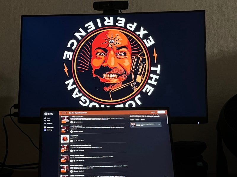 The Joe Rogan Experience podcast logo and Spotify page on two separate monitors