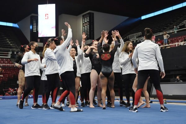 The women's gymnastic's team exchanges high fives after the meet.