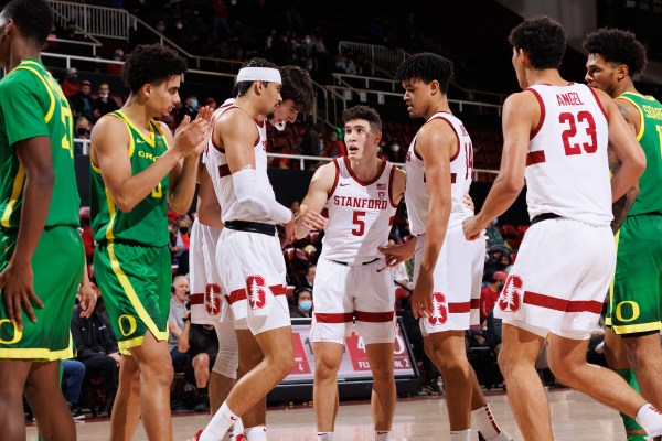 Members of the Stanford men's basketball team discuss strategy during a dead ball.