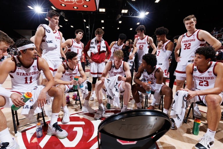 The men's basketball team huddles around during a timeout.