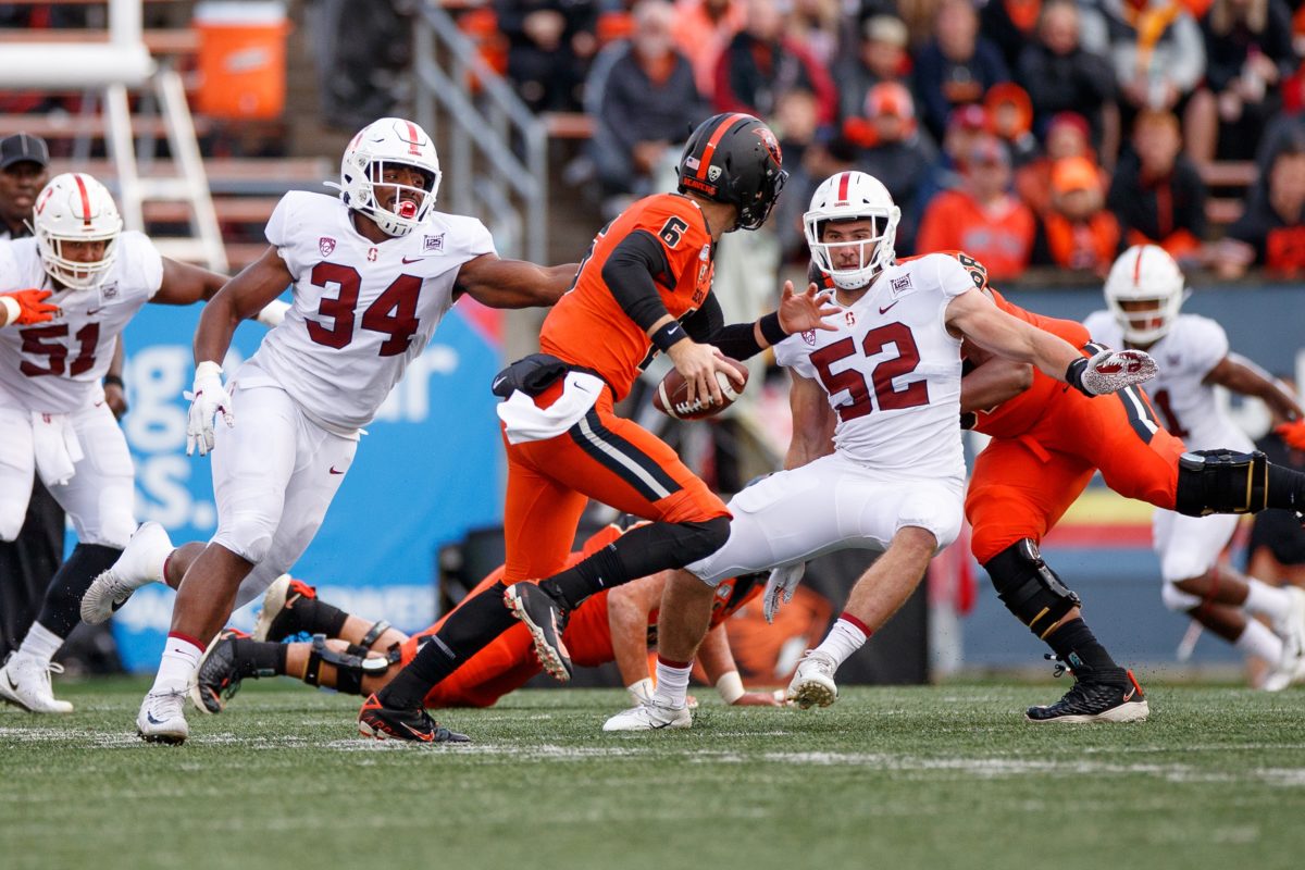 Thomas Booker (34 above) and Casey Toohill (52 above) team up to take down Oregon State quarterback Jake Luton in 2019. 