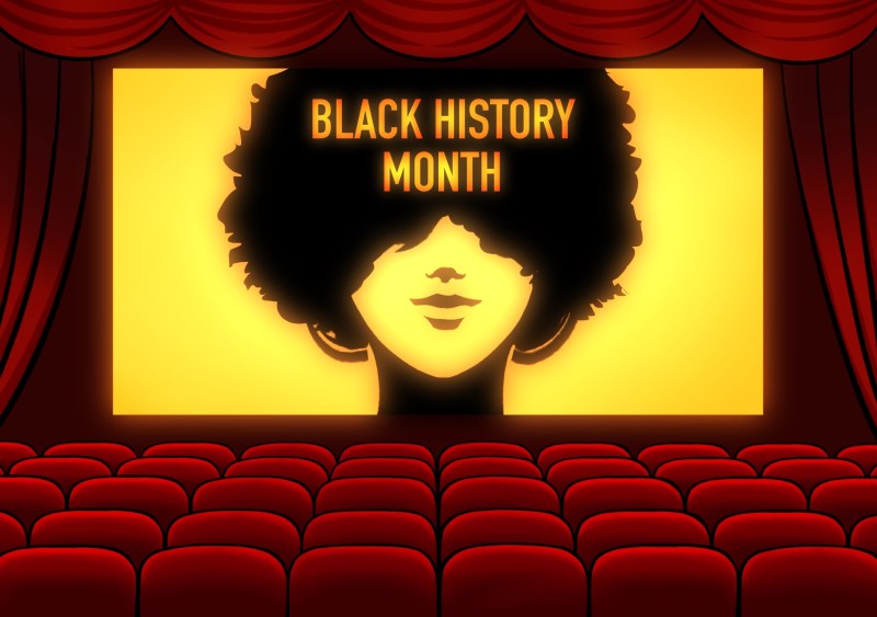 A graphic of a silhouette of a woman with an afro on the screen of a movie theater.