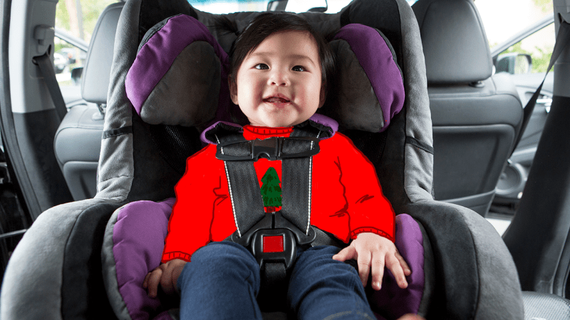 An infant in a Stanford tree shirt in a booster seat in a car