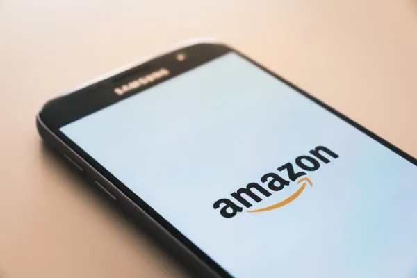 A smartphone displays the Amazon logo.