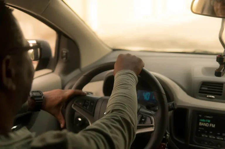 A man driving a car in daylight