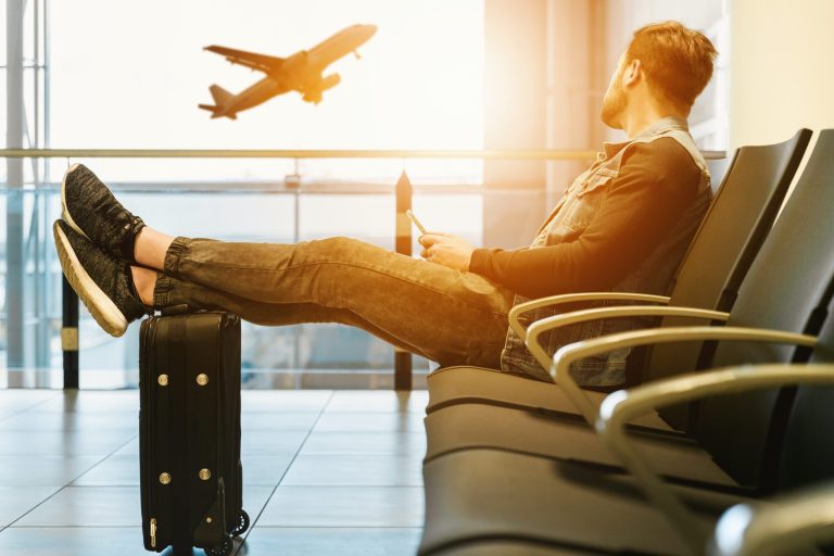 A man waits in an airport waiting area.