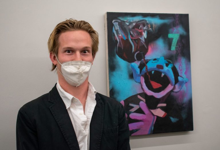 man stands in front of painting showing Sesame Street character Cont Von Count drinking from a blood bag