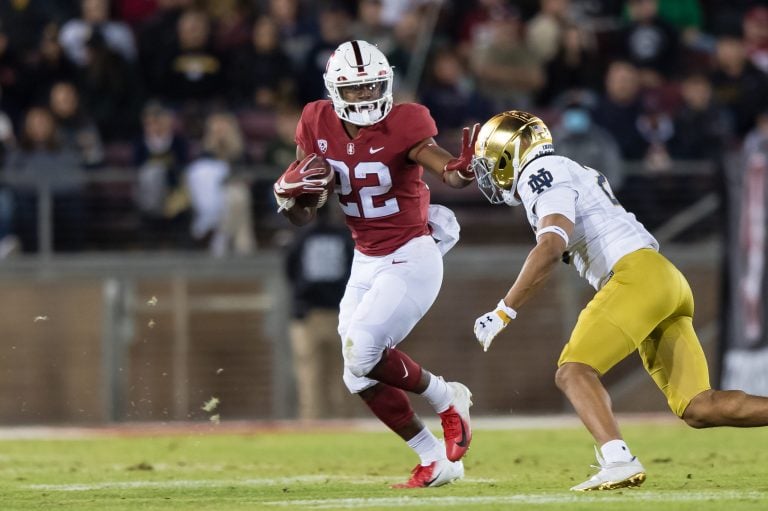 E.J. Smith stiff-arms a Notre Dame player as he runs the ball up the field.