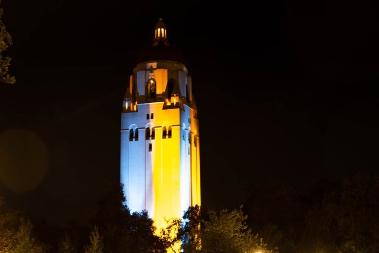 Hoover Tower lit in blue and yellow