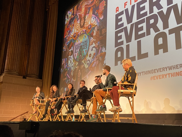 A photo of the panel discussion with cast and crew at the premiere of "Everything Everywhere All at Once." Michelle Yeoh (second left) is laughing.