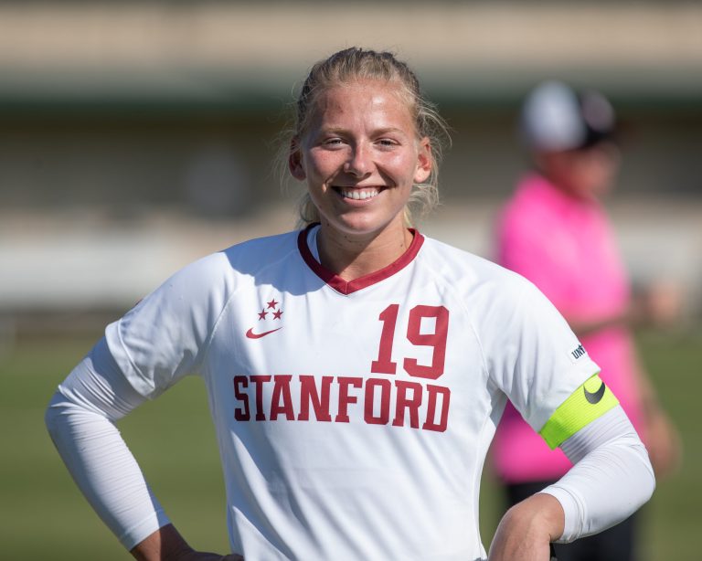 Katie Meyer in soccer gear smiles at the camera