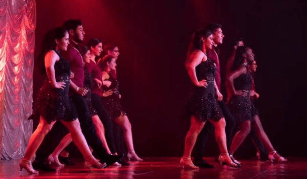 Dancers on a red light stage.