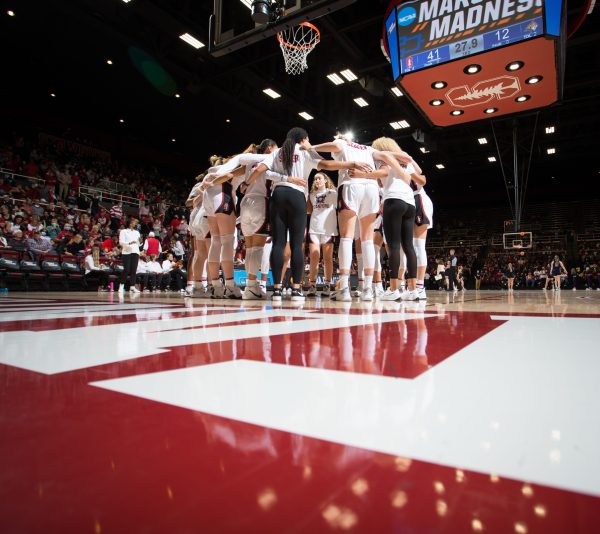 Stanford women's basketball players huddle on the court.