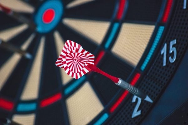 Red and white dart that is very far from the bullseye