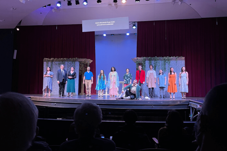 Performers on a blue lit stage.