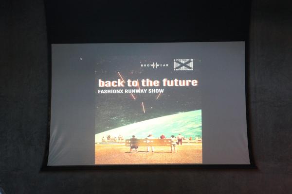 Poster of the event titled "back to the future" with a backdrop of little people standing on mars looking back at earth, with the void of the cosmos behind them.