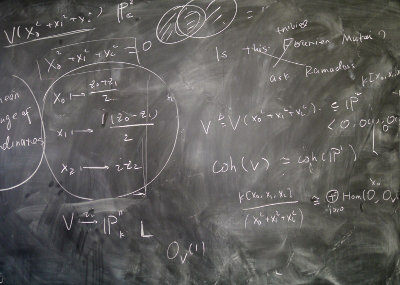 a chalkboard with various mathematical equations written in chalk