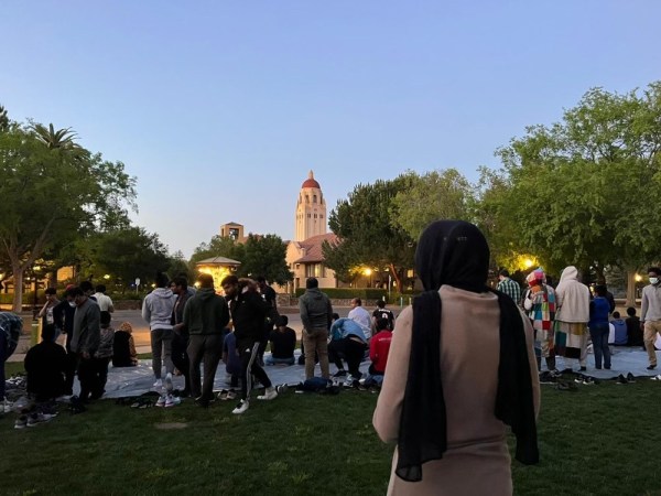 Students gather in White Plaza for Iftar, with the camera focusing one one woman wearing a black head scarf.