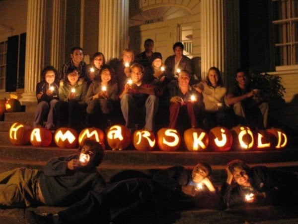 Residents of Hamm holding candles sit behind jack-o-lanterns that spell out "Hammerskjöld"