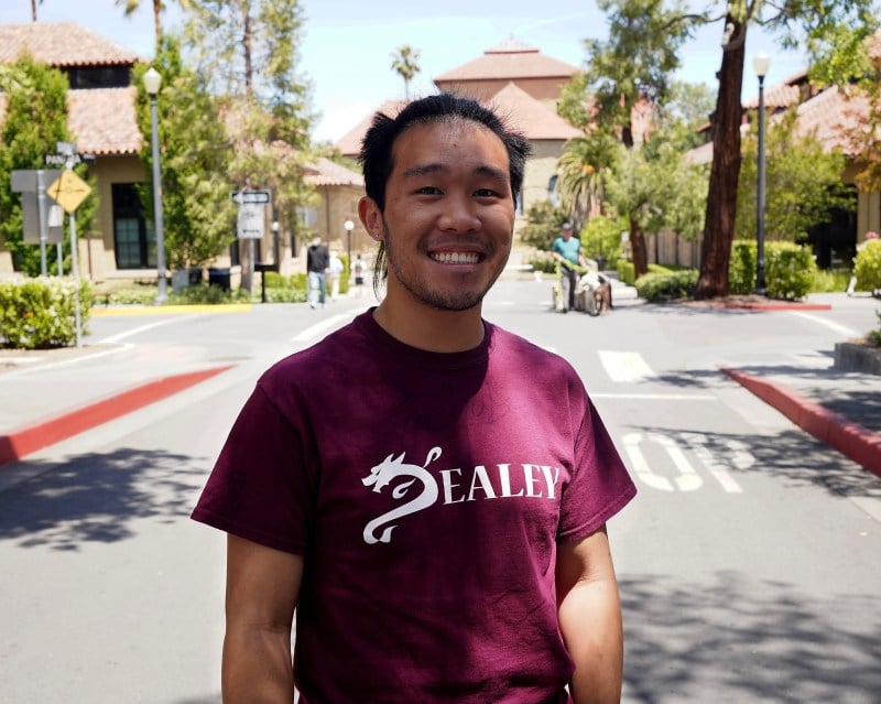 Image of Matthew Nguyen '24 smiling outside the Stanford Daily building. 