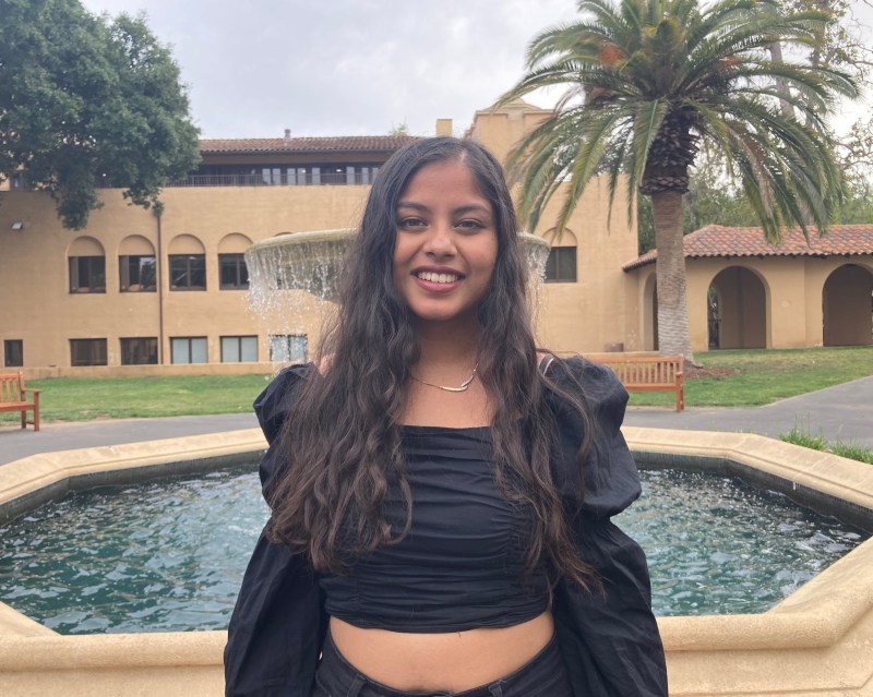 Photo of Aarushi Patil '23 smiling outside of the Old Union fountain. 