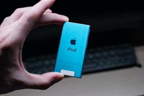 an ipod nano held between a person's thumb and index finger