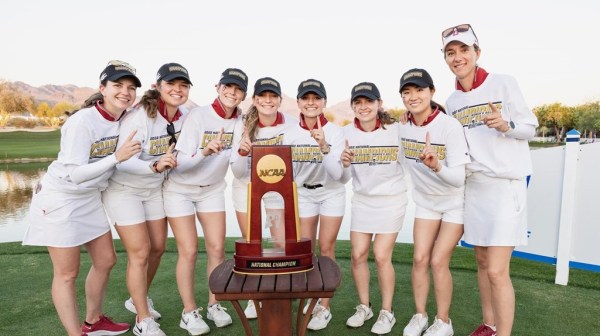 The Stanford women's golf team poses with its championship trophy.